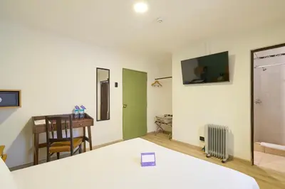 a room with a bed and a table and a desk at Centro by Casa Andina Cusco Saphi in Cusco
