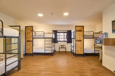 a room with four bunk beds and a table at Centro by Casa Andina Cusco Saphi in Cusco