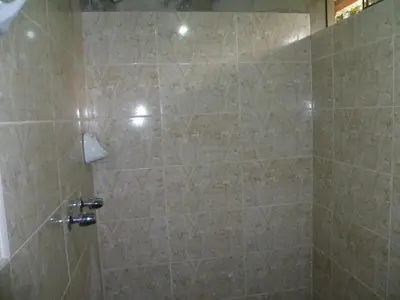a bathroom with a shower with beige tile at HOSPEDAJE CAMPOS ELÌSEOS in Oxapampa