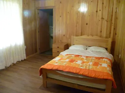 a bedroom with a bed and a wooden wall at HOSPEDAJE CAMPOS ELÌSEOS in Oxapampa