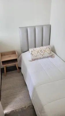 a bed in a room with a night stand next to it at El Golf los inkas luxury Penthouse in Lima