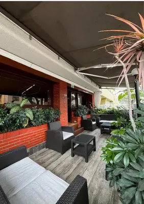 an outdoor patio with chairs and tables and plants at Hotel El Marqués in Lima