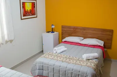 a bedroom with a bed and a yellow wall at Jazmines Lodging in Ica