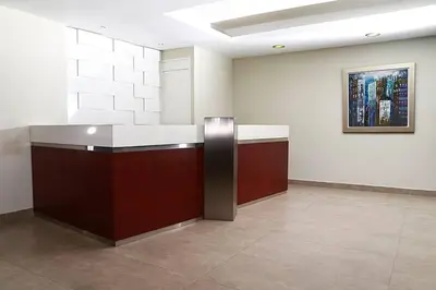a lobby with a counter and a painting on the wall at Lima Flats in Lima