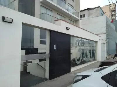 a building with a black door on a street at Beachfront Condo San Miguel in Lima