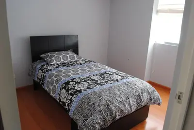 a bedroom with a bed with a black and white comforter at Beachfront Condo San Miguel in Lima