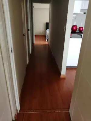 a hallway leading to a room with a hard wood floor at Beachfront Condo San Miguel in Lima