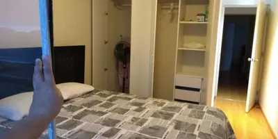 a person is holding up a bed in a bedroom at Beachfront Condo San Miguel in Lima