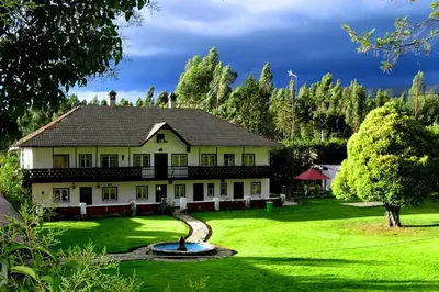 a house with a fountain in the middle of a yard at Centro Vacacional Huaychulo in Concepción