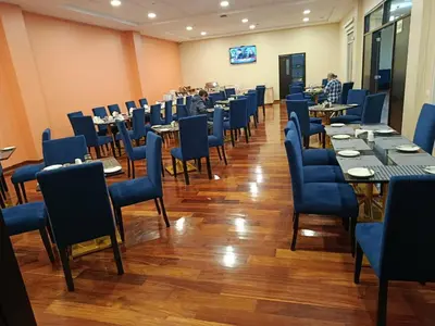 a dining room with tables and blue chairs at DM Hoteles Ayacucho in Ayacucho