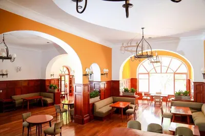 a restaurant with orange walls and tables and chairs at DM Hoteles Mossone - Ica in Ica