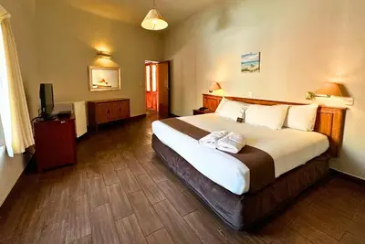 a bedroom with a large bed and a television at DM Hoteles Mossone - Ica in Ica