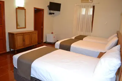 a hotel room with two beds and a mirror at DM Hoteles Mossone - Ica in Ica