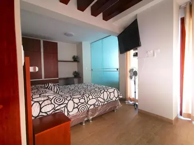 a bedroom with a bed and a flat screen tv at Residencial Cafferata in Lima