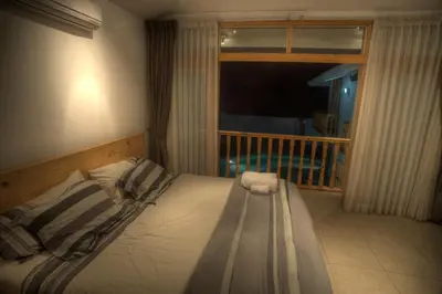 a bedroom with a bed and a window with a balcony at Hotel Boutique La Angostura in Ica