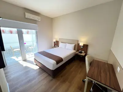 a bedroom with a bed and a table and a window at DM Hoteles Nasca in Nazca