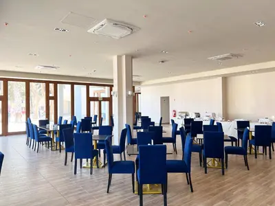 a dining room with blue chairs and tables at DM Hoteles Nasca in Nazca