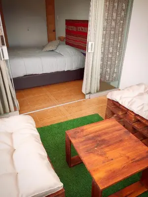 a living room with two beds and a table at Casa Mirador guesthouse in Cusco
