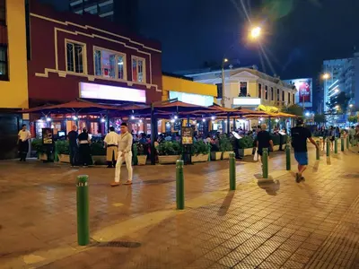 a group of people walking down a street at night at Room 5 Star Miraflores in Lima