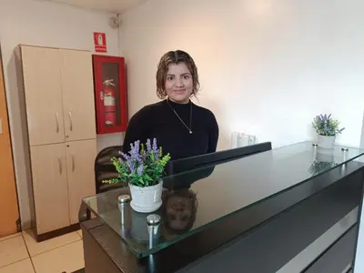 a woman is standing behind a counter with flowers at Room 5 Star Miraflores in Lima