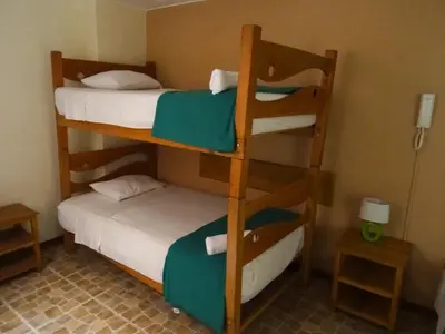 two bunk beds in a small room with a room with two smaller beds at Hospedaje La Videna in Lima