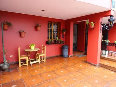 a room with red walls and a table and chairs at Hospedaje La Videna in Lima