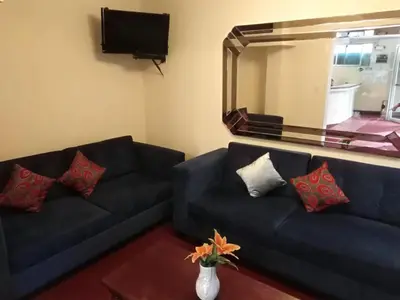 a living room with a blue couch and a mirror at Hotel Mandarin in Lima