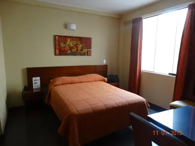 a hotel room with a bed and a window at Hotel Sumaq Inn Sac in Lima