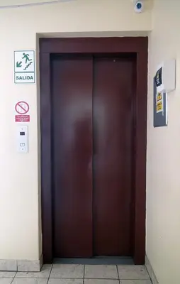 a brown elevator door in a building at Hotel Sumaq Inn Sac in Lima