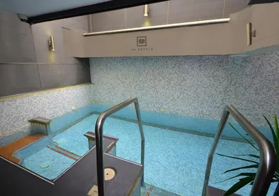 a large swimming pool in a building with an escalator at qp Hotels Lima in Lima