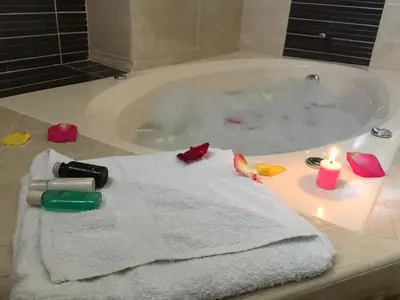 a bathroom with a bath tub with a towel and candles at Suites El Parque in Lima