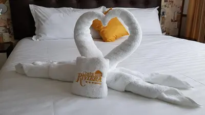 two towels shaped like swans sitting on a bed at Hotel Costa Riviera in Mala