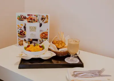 a tray with a drink and food on a table at Nobility Grand Hotel in Lima