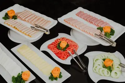 a table topped with white plates with different types of food at Nobility Grand Hotel in Lima