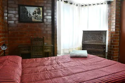 a bedroom with a red bed and a brick wall at Hotel Esperanza in Lima