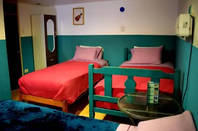 a small room with two beds and a glass table at The Chusay Rooftop in Cusco