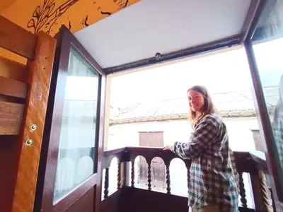a woman standing on a balcony looking out the window at Pariwana Hostel Cusco in Cusco