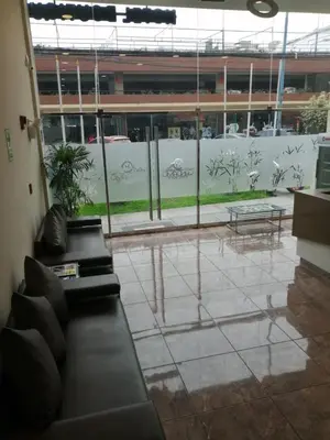 a living room with a couch and a large window at Hotel Candamo in Lima