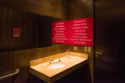 a bathroom with a sink and a red sign at Arawi Miraflores Prime in Lima