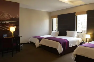 a hotel room with two beds and two windows at Arawi Miraflores Prime in Lima