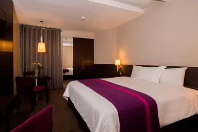 a hotel room with a large bed and a table at Arawi Miraflores Prime in Lima