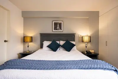 a bedroom with a large bed with two lamps at Apart Hotel San Martin in Lima