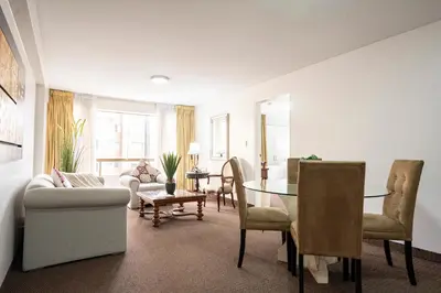 a living room with a table and a dining room at Apart Hotel San Martin in Lima