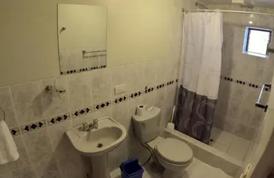 a bathroom with a sink and a toilet and a mirror at Apu Lodge in Ollantaytambo