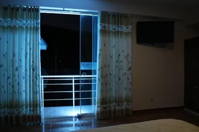 a room with a window with curtains and a television at hotel el parral suite in Ica