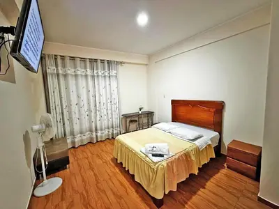 a bedroom with a bed and a television in it at hotel el parral suite in Ica