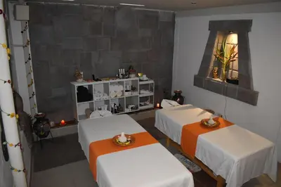 two beds in a room with two tables at HOTEL AMTALLPA San Blas Inn in Cusco