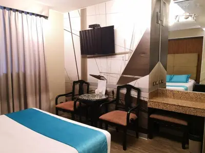 a hotel room with a bed and a table and chairs at Hotel Las Lomas in Lima