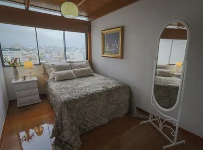a bedroom with a bed and a large mirror at Oceanfront Penthouse in Miraflores in Lima
