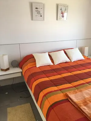 a bedroom with a large bed with pillows on it at Paracas departamento Condominio Nautico in Paracas